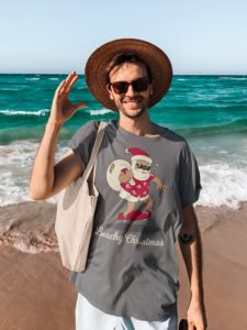 christmas t-shirt with funny santa claus with santa hat and his sack on the beach